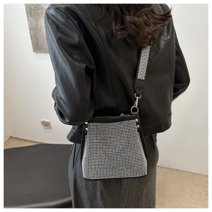 Détail du sac seau en strass avec bandoulière tissée et accents métalliques argentés