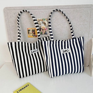Detailed view of heavy canvas tote bags with blue, white stripes and LEO patch logo