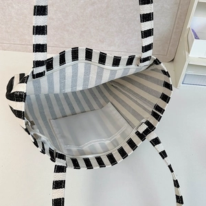 Macro view of canvas tote bag interior with striped lining, zip closure and pocket