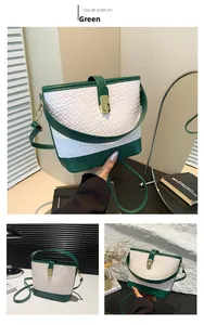 Detail view of woven textured green and white bucket bag with gold metal buckle hardware