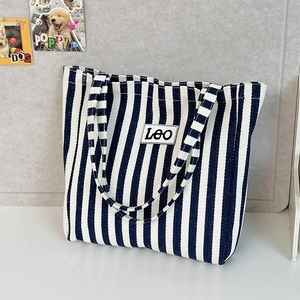 Detail of the blue and white striped canvas tote bag with a white Leo letter patch