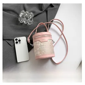 Close-up of pink bucket bag with embroidered landscape pattern and metallic zipper