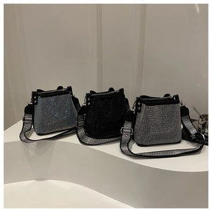 Vista de detalle de tres bolsos tipo cubo con pedrería en azul, negro y plateado