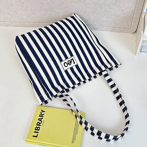 Close-up of blue and white striped canvas tote bag with a Leo letter patch
