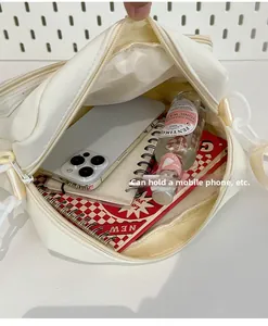 Detailed interior of a beige crossbody bag showing space for smartphone and notebook