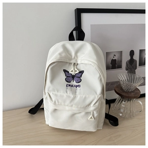 Detailansicht des cremeweißen Rucksacks mit lila Schmetterlingsdruck und Dreams-Text