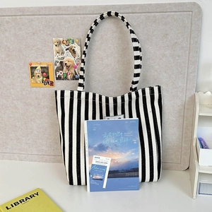 Detail shot of blue and white striped canvas tote bag with small front woven patch