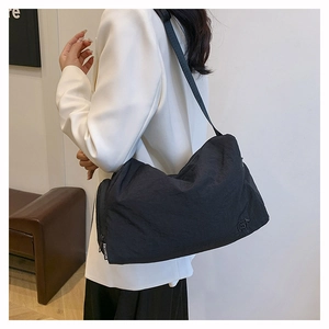 Détail d'un sac cabas en nylon noir avec texture plissée et tirette de zip marquée