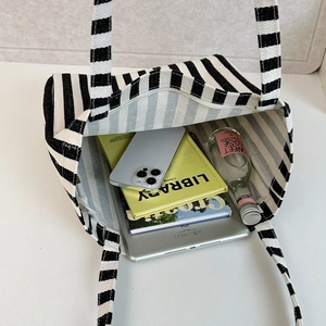 Internal view of blue striped canvas tote bag showing large capacity for laptop and books