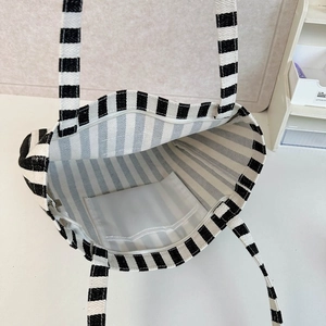 Detail view of large canvas tote bag interior with striped pattern and secure zipper pocket