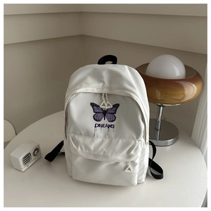 Detailansicht des weißen Rucksacks mit lila Schmetterlingsdruck und Reißverschluss