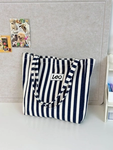 Detail of blue and white striped canvas tote bag with LEO logo and textured fabric finish