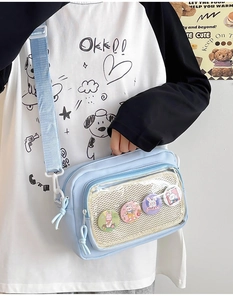 Detail of light blue crossbody bag with clear window pocket and four cute rabbit badges