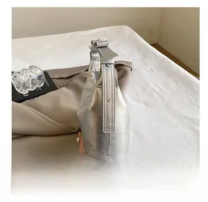 Detailansicht der silbernen Lederstruktur mit Rissoptik und der präzisen Nähte der Tasche
