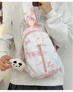 Detalle del bolso bandolera blanco tie-dye con estampado rosa y colgante de peluche panda