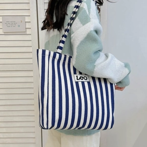 Close-up of blue and white striped canvas tote bag with Leo patch detail and large capacity