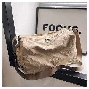 Vue détaillée du tissu en nylon beige résistant à l'eau et du double zip sur le sac