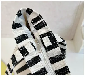 Close-up of durable silver metal zipper on blue and white striped canvas tote bag