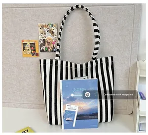 Vertical striped canvas tote bag size comparison with an A4 magazine for capacity