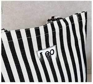 Detail of blue and white striped canvas tote bag showing textured fabric and LEO label