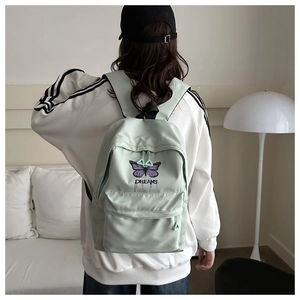 Detail der lila Schmetterlingsstickerei und Dreams-Schriftzug auf mintgrünem Rucksack