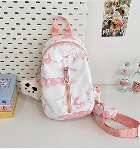Detalle del bolso bandolera tie-dye con estampado de paisaje rosa y colgante de panda