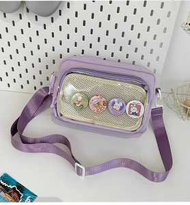 Detail of purple ita bag with clear PVC window showcasing cartoon bunny badges and mesh