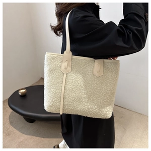 Dettaglio della borsa tote in pile orsetto crema con tracolla in pelle beige sul modello