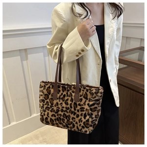 Detalle del bolso tote de peluche con estampado de leopardo y asas de cuero marrón