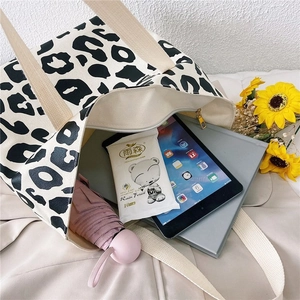 Spacious interior of leopard print canvas tote bag with tablet and daily essentials