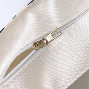 Detailed macro view of the premium golden metal zipper on a pink leopard canvas tote bag