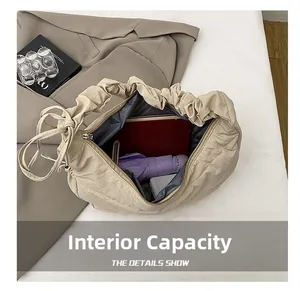 Spacious interior of beige pleated cloud bag showing storage for umbrella and wallet