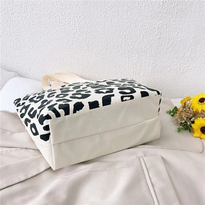 Detail of canvas tote bag featuring leopard print contrast and sturdy woven handles