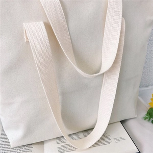 Detail of high-density canvas texture and sturdy woven handle on a minimalist tote bag