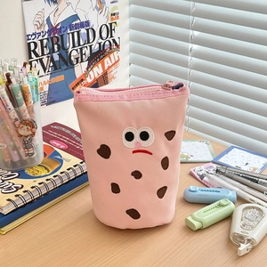 Close-up of pink canvas stationery bag with cute embroidery on a wooden desk