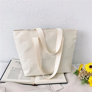 Detailed macro view of large capacity cream canvas tote bag with textured weave handles