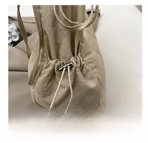 Detail showing high-density pleated texture and silver spring buckle on a drawstring bag