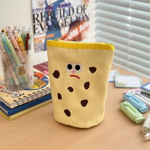 Detailed view of upright yellow canvas pencil case with cute biscuit embroidery decoration