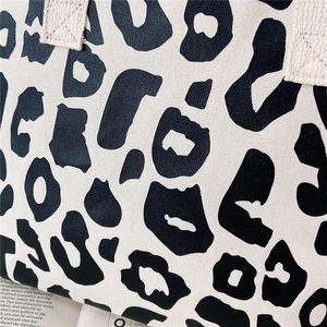 Close-up of leopard print canvas tote bag featuring cross-stitch reinforced straps