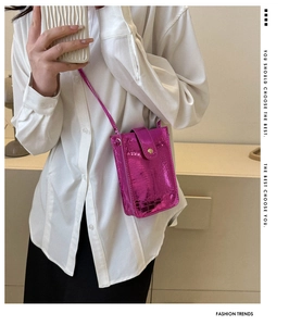 Detail view of the rose red crocodile pattern phone bag with a glossy finish and gold button