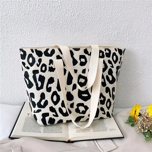 Detailed close-up of high-capacity canvas tote bag with black and white leopard print
