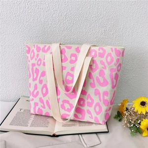 Detail of pink leopard print canvas tote bag on magazine with sunflower background