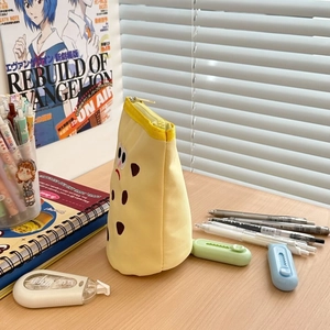 Detailed view of yellow canvas pencil bag with funny cartoon expression and zipper