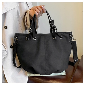 Detail van de grote zwarte canvas shopper met verstelbare schouderband en handgrepen