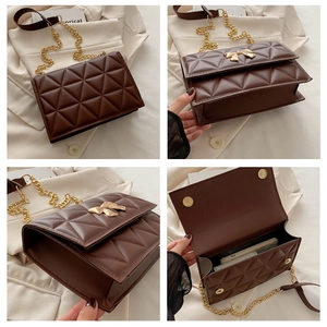 Detail view of brown quilted bag with gold bow buckle and chain strap showing interior