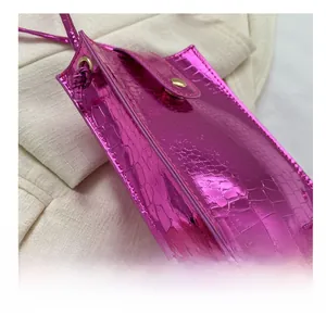 Close-up of metallic purple crocodile texture mini phone bag with golden button snap