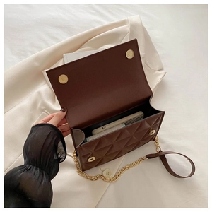 Detail view of the brown quilted crossbody bag interior with gold chain strap