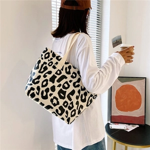 Detailed view of the large leopard print canvas tote bag on a wooden table setup