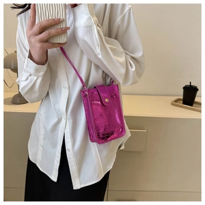 Detail of metallic pink crocodile embossed leather phone bag with flip cover and long strap