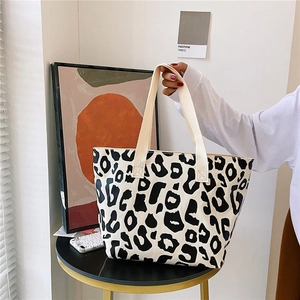 Detailed macro view of a pink leopard print canvas tote bag with cream webbing handles